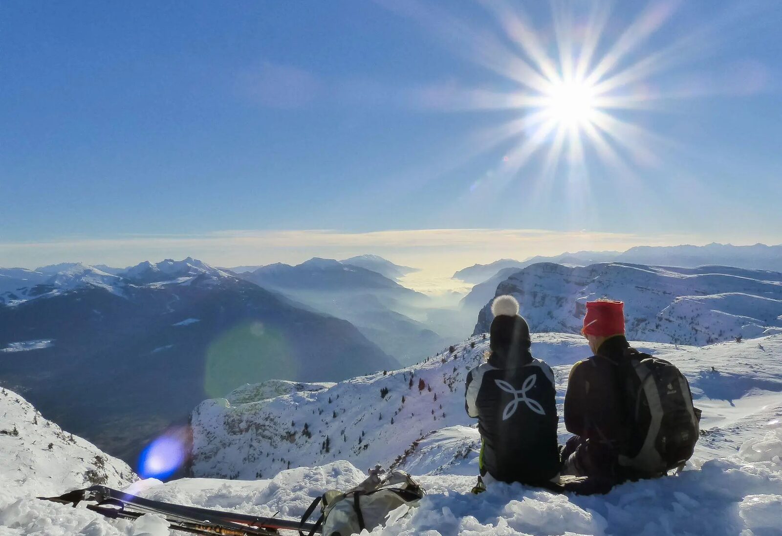 Persone sulla neve davanti al panorama della Paganella